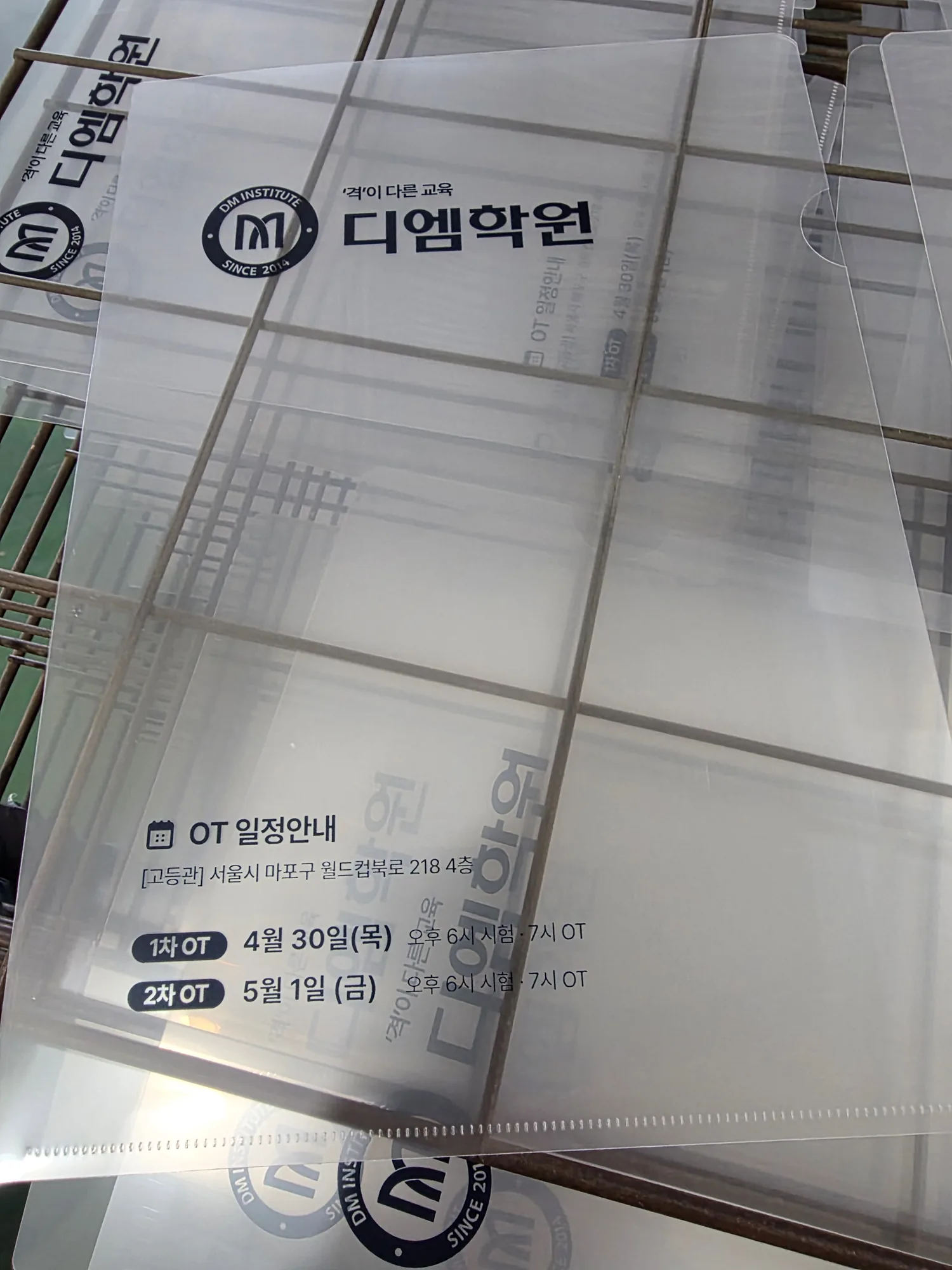 투명 PP L자파일이 여러 장 겹쳐 쌓여 인쇄 내용이 보이는 모습